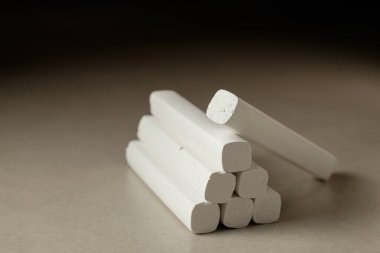 Yığılmış beyaz tebeşir parçaları yumuşak ışıkta pürüzsüz bir yüzey üzerinde dinleniyor