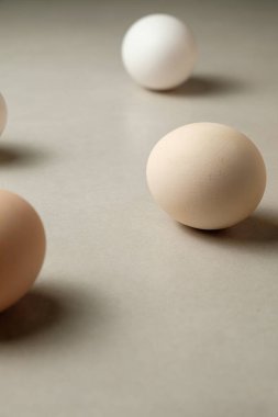 Tarafsız bir mutfak yüzeyinde farklı tonlarda beş güzel yumurta var. Yumuşak dokuları ve yumuşak renkleri evde sakinleştirici ve davetkar bir atmosfer yaratıyor..