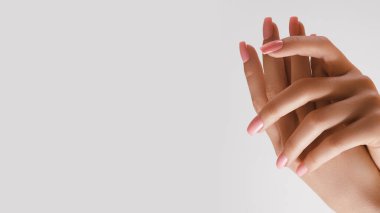 Güzel Kadın Elleri. Yumuşak ten, cilt konsepti. El Cildi Bakımı. Kadın Elleri Krem veya Losyon Uygular. Spa ve Manikür konsepti. Yumuşak pembe manikürlü kadın elleri