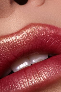 Makro yakın plan kadın dudakları kalın ve canlı rujla, şık bir görünüş için mükemmel uygulanmış. Zarif makyaj, zengin renk tonları, baştan çıkarıcı ve çekici öpücük ifadesi. Güzellik, makyaj ve moda için ideal