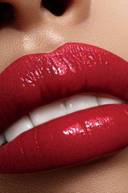 Parlak kırmızı rujla güzel dolgun dudakların makro ayrıntıları. Güzellik, moda, cilt bakımı ve kozmetik reklamcılık için mükemmel bir makyaj. Baştan çıkarıcı kadın ağzı. Kırmızı dudak makyajlı, dolgun dudaklar. Doldurucu Enjeksiyonlar, Plastik Cerrahi