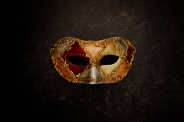 Karanlık arka planda canlı Venedik maskesi. Yüksek kalite fotoğraf. Kaliteli boyalarla süslenmiş Venedik maskesi. Karnaval maskesi. 
