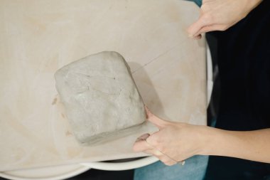 Potter, Seattle, Washington 'daki seramik stüdyosunda kil kesiyor. Yüksek kalite fotoğraf. Basit tahta..