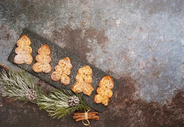 stock image christmas puff pastry cookies in the form of fir trees on a black board on a dark table. view from above