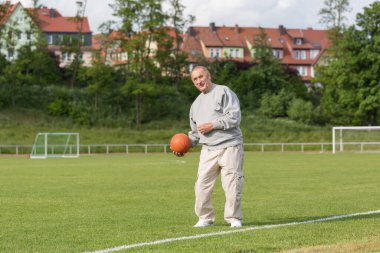 Yaşlı bir adam bir yaz akşamı stadyumun arka planında spor için içeri girer.