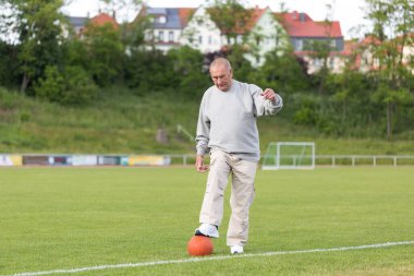 Yaşlı bir adam bir yaz akşamı stadyumun arka planında spor için içeri girer.