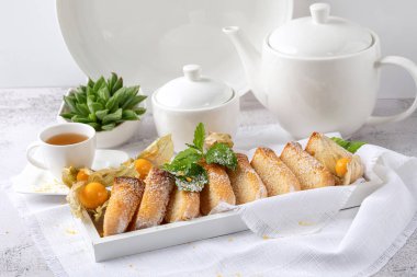 Beyaz arka planda beyaz bir tabakta limonlu bisküvi.