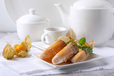 Beyaz arka planda beyaz bir tabakta limonlu bisküvi.