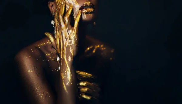 アートファンタジーの肖像画アフリカ系アメリカ人女性の女神 女性の手を閉じて 黄金の塗料で指 女王様風だ 創造的な金属の専門家のメイクの唇の光沢液金滴 ブラックスタジオ — ストック写真