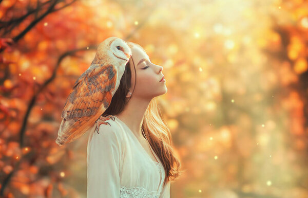 Fantasy girl princess teenager with white bird barn owl on shoulder. Eyes closed pretty face enjoying magical divine sun light. Bright colorful nature forest trees. vintage dress dream magic concept