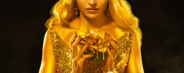 Art photo fantasy woman queen holding in hands metal liquid gold dripping rose flower. Night Black studio. Blonde hair girl fairy princess golden skin sexy lips beauty face cropped. midas hand gilding clipart