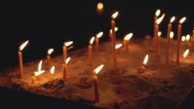 Tapınakta mumlar yanıyor. İnsanların duaları. Karanlıkta turuncu alevler. Kederin ve yasın ışığı.