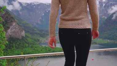 Mutlu kadın gözlem güvertesinde yürüyor. Kız turist, Hallstatte Gölü 'nün manzarasının keyfini çıkarıyor. Seyahat eden kişi yeşil doğa gökyüzü bulutları. Dağlar Avusturya Gölü Turizm Köyü Hallstatt. Arka arkaplan