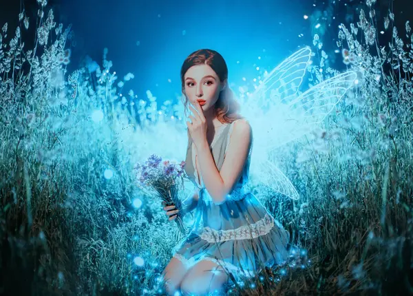 Sanat fotoğraflı fantezi peri kız kelebek kanadı. Seksi kadın peri ışıltılı kanatları, gece karanlığında çiçek tutar doğa yıldızı ışığı. Parmak işaretleri sır tutar. Güzel yüz makyajı kırmızı dudaklar.