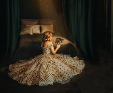 Glamour rozeti, gecenin karanlığında yatağın kenarında oturan, eski tarz telefon bekleyen, çekici kadın. Klasik siyah bej renkli, bej renkli bir elbise. Üzgün seksi kız resmi 50 'lerin arkası..