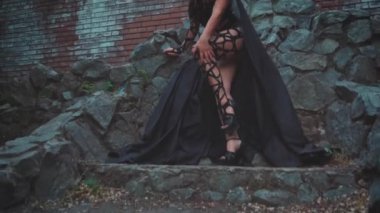 Gürültülü video. Fantezi kadın Medusa gorgon Yunan tanrıçası. Siyah gotik karnaval kostümü. Taş tahtta oturan manken kız. Başında altın yılanlar, korkunç makyajlar. Kara Kraliçe cadı.