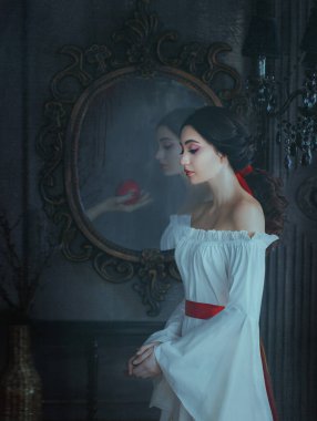 Portre güzel kadın konsepti uyuyan güzel korku rüyası. Peri masalı ortaçağ kıyafetleri. Gotik kız prenses makyajı kırmızı dudaklar. Zehirli elmalı hayalet kadın eli klasik aynanın yansımasıdır.