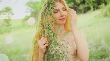 Uzun, sağlıklı, doğal sarışın güzel bir kadının portresi. Orman prensesi kılığındaki güzel sarışın bir kızın tatlı yüzü. Nazik, utangaç bir gülümseme. Arka plan yazı, yeşil, bahar doğası