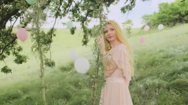 Uzun, sağlıklı, doğal sarışın güzel bir kadının portresi. Orman prensesi kılığındaki güzel sarışın bir kızın tatlı yüzü. Nazik, utangaç bir gülümseme. Arka plan yazı, yeşil, bahar doğası