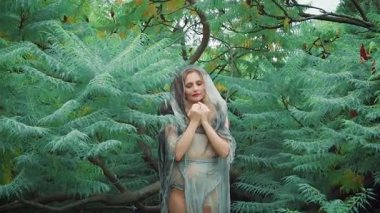 Pamuk Prenses ve Yedi Cüceler masallarındaki kötü cadı ona zehirli, lanetli ve büyülü bir elmayla davranıyor. Kapüşonlu gri cüppeli sihirbaz suretinde olgun gizemli bir kadın.