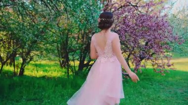 Genç, mutlu kadın dikiz aynası, akşam saç stili, saçlar toplanmış. Masal prensesi. Kız modası mezunu. Pembe gelinliğin arkası açık. Yeşil çimlerde çıplak ayakla yürüyen bir kadın, yaz çayırlarında.