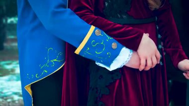 Aşıkların elleri yakındır. Dantelli kırmızı kadife elbiseli bir kadın, ortaçağ prensinin elini tutuyor. Adam karısının karnına hafifçe dokunur. Zarif mavi kaşkorse. Arka plan siyah at, kış doğa ormanı.