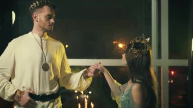 Gürültülü eski tarz film. Siluet, ortaçağ giysisi giymiş iki insan ve kadın hayaleti. Guy Prince prensesi elle kucaklıyor. Birbirine aşık çiftler. tarihi elbise