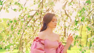 Fantezi kadın kraliçe eli dallara dokunuyor beyaz elma çiçekleri yeşil meyve bahçesi ışığı parlıyor. Mutlu kız yüzü, bahar doğasının tadını çıkar. Sağlık konsepti, alerjilerden arınmış.