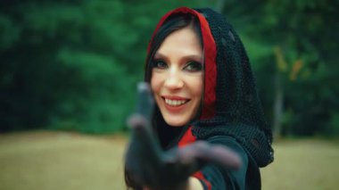 Portre fantezisi mutlu kadın cadı dönen, dans eden el sallayan davetiye. Neşeli gülümseyen yüzlere bakıyorum. Başlıklı, siyah kırmızı elbiseli. Doğa yeşili orman, ağaçlar. Gizemli kız vampir. 