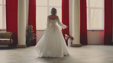 Genç bayan kraliçe pencereden dışarı bakıyor, aşkı bekliyor. Fantezi perisi bayan Mutlu Prenses sarı saçlar, beyaz ipek kumaş uzun elbise eski tarz fildişi arka plan sanat 4k