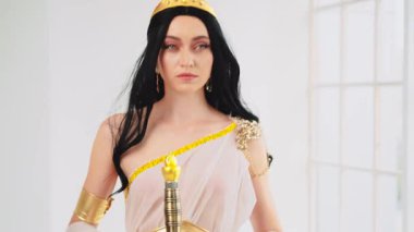 Yunan savaş tanrıçası Athena 'nın antik çelik kılıcı elinde tuttuğu fantezi portresi. Yaratıcı tasarım ipekten elbiseler yaratıcı elbise altın aksesuarlar klasik kostüm. Uzun saçlar rüzgarda uçuşuyor