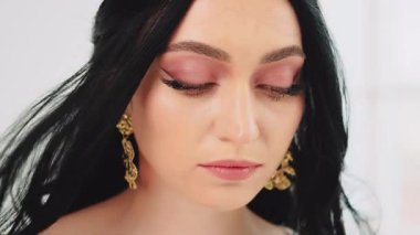 Model mükemmel pembe profesyonel makyaj, büyük seksi yeşil gözler mükemmel cilt güzellik portresi Yunan tanrıçası esmer kadın saçlar rüzgarda uçuşuyor. Kız kameraya bakıyor. Antika tarzı altın taç.. 