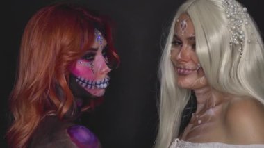 Güzel, yaratıcı iskeletleri olan iki kadın poz veriyor ve kameraya bakıyor. Modeller, bir makyözün çalışmalarını yenilikçi bir tarzda sergilemektedir. Calavera Catrina Cadılar Bayramı