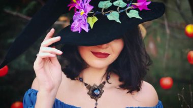 Mutlu cadılar bayramı kadını yakın plan seksi portre gülümseyen şeytan yüzü şapkası, şenlik makyajı kırmızı dudaklar fantezi kız saçı siyah kostüm koni şapkalı karnaval resmi mücevherleri. 