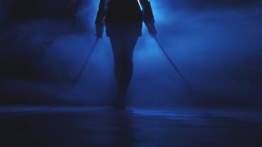 Siyah siluet fantezi kadın suikastçı iki katana kılıcı tutuyor. Siyah arka plan mavi ışık tam duman. Peri asker kız yüzü kesilmiş. Silahlı seksi kız prenses. Ortaçağ silahı