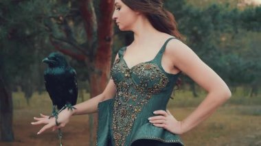 Elinde siyah kuzgun avcısıyla dişi kara elf savaşçısı. Değerli taşlar ve metalle işlenmiş yaratıcı siyah deri korse. Kuş evcil hayvanı olan seksi cadı. Saldırgan Vahşi Yaşam Çekimi. 