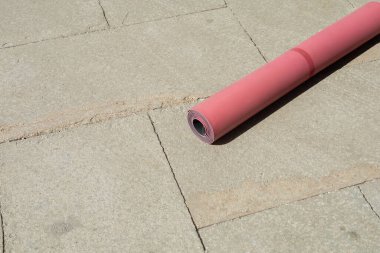 High angle view of fitness mat on sidewalk on urban street in sunny day, summertime clipart