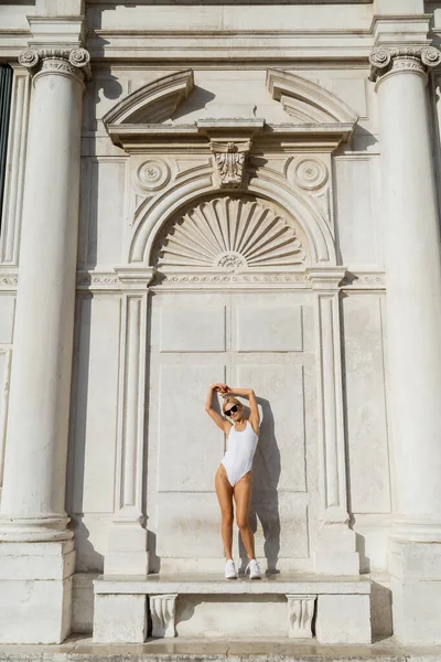 Αθλητική Γυναίκα Γυαλιά Ηλίου Και Bodysuit Στέκεται Στον Πάγκο Κοντά — Φωτογραφία Αρχείου