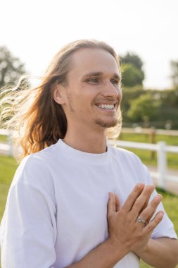 Genç ve kaygısız yoga adamı gözlerini kaçırıyor ve dışarıda Anjali Mudra jesti gösteriyor.