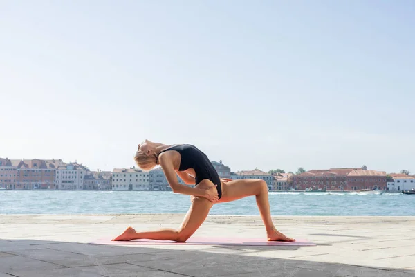 Сторона зору жінки, що розтягується під час практики йоги на набережній Венеції. — стокове фото