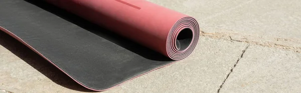 Pink fitness mat with shadow on asphalt sidewalk on urban street in sunny day, summertime, banner — Stock Photo