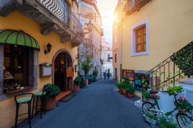 Küçük caddeleri ve çiçekleri olan eski güzel Taormina kasabası. Taormina 'da kemerli ve eski kaldırımlı bir mimari. Eski Taormina kasabasında renkli dar bir cadde. Sicilya, İtalya. 