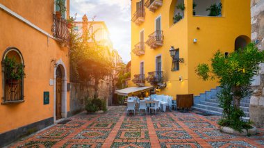 Küçük caddeleri ve çiçekleri olan eski güzel Taormina kasabası. Taormina 'da kemerli ve eski kaldırımlı bir mimari. Eski Taormina kasabasında renkli dar bir cadde. Sicilya, İtalya. 