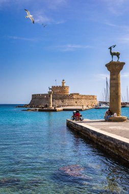 Geyik heykeli olan Mandraki limanı, Heykelin durduğu yer ve Aziz Niklas kalesi. Rodos, Yunanistan. Rodos, Rodos, Yunanistan Heykeli 'nin yerine Hirschkuh heykeli