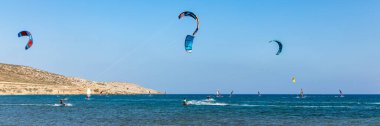 Surfers in Prasonisi Beach in Rhodes island, Greece. Kiteboarder kitesurfer athlete performing kitesurfing kiteboarding tricks. Prasonisi Beach is popular location for surfing. Greece