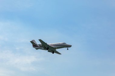 Landing airplane. Landscape with passenger airplane is flying in the blue sky with clouds. Passenger airliner. Business trip. Commercial aircraft. Passenger airplane flying and getting ready to land.