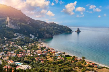 Yunanistan 'ın Korfu adasındaki Agios Gordios egzotik plajı. Agios Gordios plajı, Korfu adası, Yunanistan. Agios Gordios plajının panoramik manzarası, kumlu deniz kıyıları, plaj şemsiyeleri ve şezlonglar..