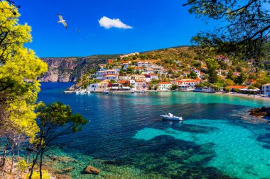 Yunanistan 'ın Kefalonya kentindeki Assos köyünde güzel renkli evleri olan Akdeniz' deki turkuaz renkli körfez. Akdeniz 'de renkli evleri olan Assos kasabası, Yunanistan. 
