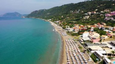 Yunanistan 'ın Korfu adasındaki Agios Gordios egzotik plajı. Agios Gordios plajı, Korfu adası, Yunanistan. Agios Gordios plajının panoramik manzarası, kumlu deniz kıyıları, plaj şemsiyeleri ve şezlonglar..