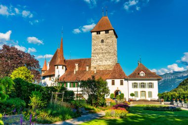 Günbatımında İsviçre 'nin Bern kantonundaki Thun Gölü kıyısındaki Spiez Kilisesi ve Kalesi manzarası, Spiez, İsviçre. İsviçre, Bern kantonunda Thun Gölü 'ndeki Spiez Şatosu.